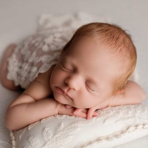 baby on white pillow Maddy Rogers newborn training uk