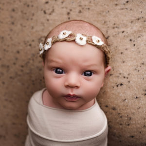 wide awake baby girl with brown eyes Maddy Rogers Newborn training UK