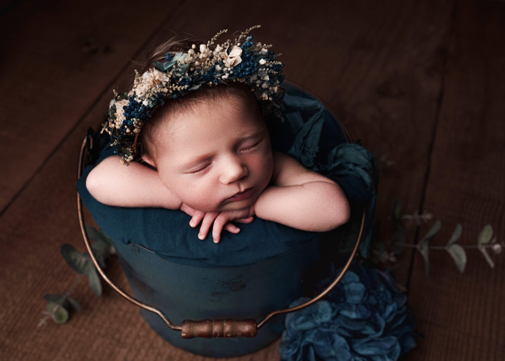 new baby alseep in a tin bucket with flowers Maddy Rogers Photography Yorkshire
